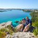 A couple sits on a rock overlooking The Great Sound