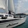 A group of people on a catamaran with a sign that reads Aristocrat