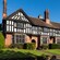 A building featuring archways, windows, chimneys and a front lawn