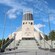 A teepee shaped building with a tower of spires flanked by 2 colorful vertical structures