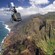 Vista aérea de un helicóptero sobre una costa y un cañón con áreas de césped y follaje