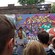 Una mujer habla con una multitud frente a una pared con grafiti artístico