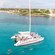 People swimming in the ocean by a catamaran with passengers close to shore