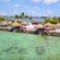 A row of cabanas near trees, bodies of water and a distant town