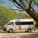 A van with a sign that reads Cielo Azul near a tree