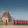 Un grupo de soldados con atuendos ceremoniales cerca de un palacio