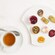 Té acompañado de galletas, tartas, panecillos y mermelada de frambuesa y de naranja
