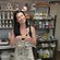 In a soap making lab, a smiling woman shows off the soap she made and a man carries his in a bag