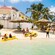 A shorefront property featuring a beach with adults and children, kayaking equipment, umbrellas, lounge chairs and more
