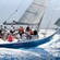 Passengers smile and enjoy the sea air as their sailboat races on the waves of the ocean