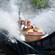 A group of young teenagers splash through the waters of a log flume ride