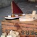 3 model boats in various stages of completion sit on a wooden box next to model building materials
