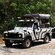 4 by 4 vehicles carry passengers over a forested backroad