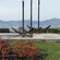 Stone platform with rectangular fountain and a sculpture of 3 anchors overlook a bay and coast line