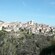 A large old city perched on a hillside next to the ocean