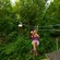 A woman riding a zip line through the jungle