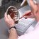 A man using a mini spatula to spread melted chocolate from a metal bowl onto a plastic bar mold