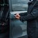A man opening the door to a van with empty seats inside