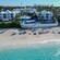 Sunbathers beneath umbrellas along the shore of Paradise Island Beach Club in Nassau, Bahamas