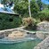 A lush garden with a brick waterfall and wooden bridges at El Gallo Ecolodge