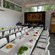 A cooking classroom featuring fresh produce sitting on the cutting board in front of each chair at long tables