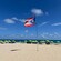 A Puerto Rican territorial flag and shaded outdoor furniture on a sandy beach in San Juan