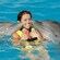 A woman being nuzzled by 2 dolphins in the water at Dolphinaris in Cozumel, Mexico