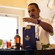 A Casa Bacardi tour guide giving an explanation on drink preparation behind a counter with rum bottles and drinks