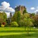 Blarney Castle rising above lush gardens and trees on the castle grounds in Ireland
