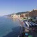 The shoreline of Camogli Beach with buildings, lounge chairs and umbrellas in Genoa, Italy
