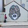 A Guest riding a Segway past a mural of a face on a Stavanger Port Authority building