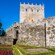 The exterior of Soutomaior Castle with a wooden door on one of the side walls next to a garden