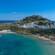 Aerial view of a bay in Rhodes, Greece, with beaches, coastal buildings and Lindos Acropolis on a hill
