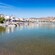 A calm waterfront in Rhodes with small boats, seaside buildings and a hilltop fortress