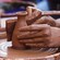 A Guest shaping a clay vase on a pottery wheel