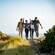 Four friends walking on a dirt pathway along the coastline of Lower Ballast Point