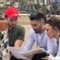 Three teammates crouching together to study a printed clue sheet while in a brick plaza in Avalon