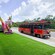 A classic trolley car parked on the curb beside a sculpture