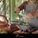 A chef preparing guacamole in a stone bowl during a cooking class in Cozumel, Mexico