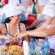 Two women in chef hats laugh together while making salsa at a shared cooking station