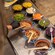 A child in a chef’s hat looking over a spread of fresh taco toppings in clay bowls