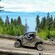 Guests driving UTVs along a dirt trail overlooking Icy Strait