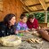 A guide showing 3 Guests sitting at a table how to make a drum by hand