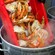 Several crab pieces being dumped into a steaming pot