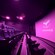 Rows of MX4D theater seats facing a large, curved screen with the SEAMAX Alaska logo inside an auditorium