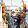 A crab fisherman holding up 2 large king crabs