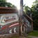 A wooden cultural building featuring totem poles and a mural at Saxman Native Village