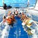 A small group of people wearing life jackets while cruising open waters in a glass bottom boat