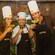 A couple wearing chef hats and drinking cocktails with the mixology expert at The Mayan Cacao Company in Cozumel, Mexico
