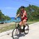 A woman riding an electric bicycle next to a beach in Cozumel, Mexico